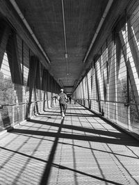 Rear view of man walking on bridge