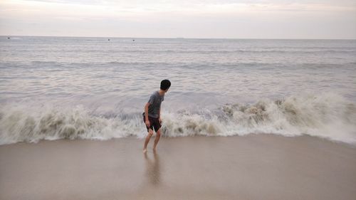 Man standing in sea against sky