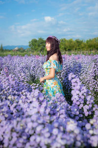 Rear view of woman with umbrella on field