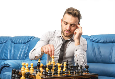 Full length of man sitting on sofa