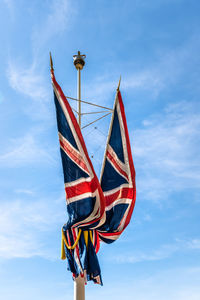 Union jack flags waving against blue sky.