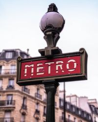 Metro text on pole against sky