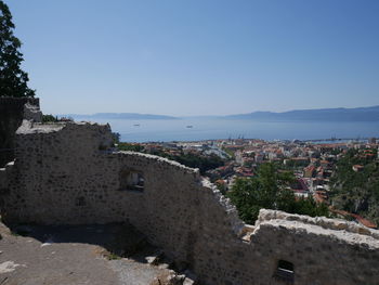 Townscape by sea against clear sky