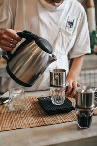 Midsection of man holding coffee cup