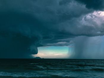 Scenic view of sea against storm clouds