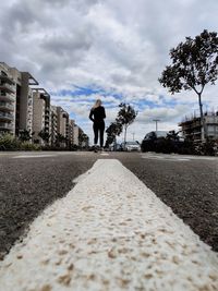 Rear view of man walking on road in city