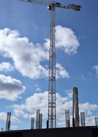 Low angle view of cranes against buildings