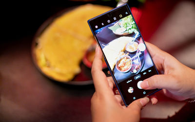 Females are holding smartphones and taking photos of the vietnam food for show to their social media