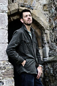 Man leaning on wall of historic building