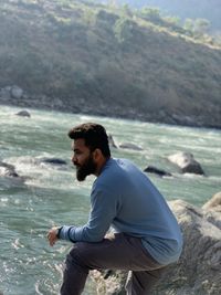 Side view of young man looking at sea