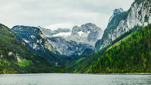 Scenic view of lake by mountains against sky