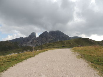 Road leading towards mountains against sky