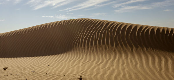 Sand dune in desert against sky