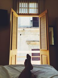 Low section of man lying on bed against door