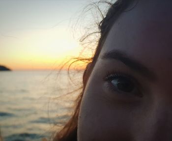 Close-up portrait of woman against sky during sunset