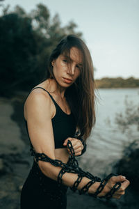 Portrait of young woman standing at beach