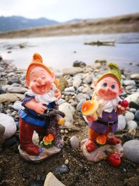 Close-up of figurines on shore at beach