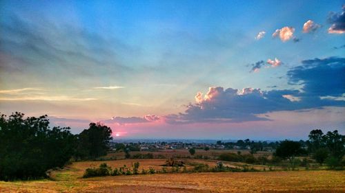 Scenic view of field against cloudy sky