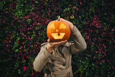 Rear view of woman holding pumpkin