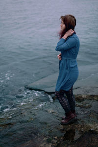 Young girl on a background of the sea in a blue dress, portrait