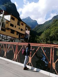Man standing by bridge against sky