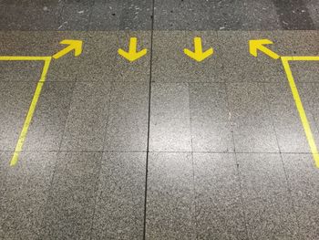 High angle view of yellow arrow symbol on road