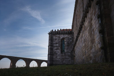 Low angle view of bridge against cloudy sky