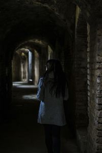 Rear view of woman walking in corridor