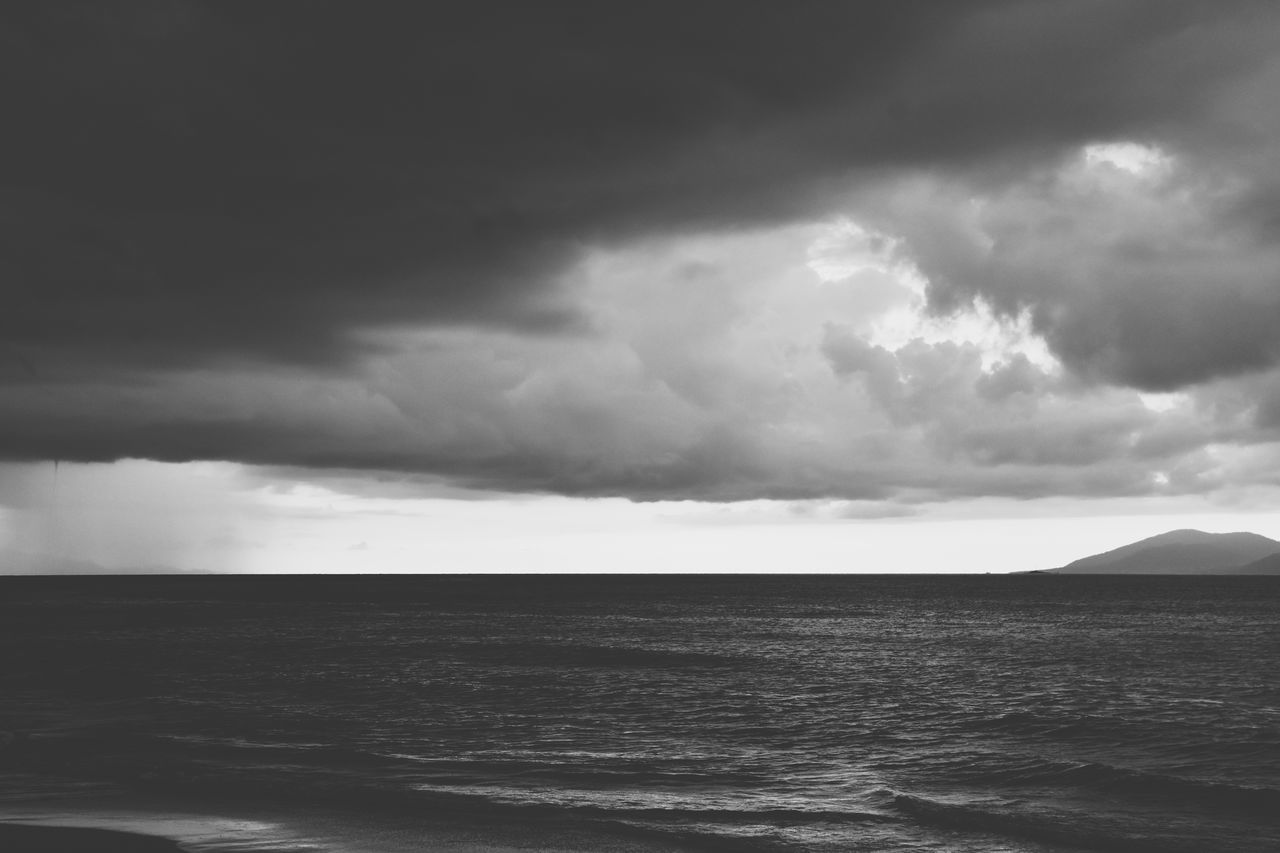 sky, cloud, sea, water, black and white, beauty in nature, storm, horizon, scenics - nature, ocean, monochrome photography, monochrome, environment, nature, wave, land, storm cloud, dramatic sky, wind wave, horizon over water, coast, thunderstorm, beach, overcast, no people, tranquility, outdoors, cloudscape, ominous, tranquil scene, landscape, shore, seascape, dark, awe, black, day, travel destinations