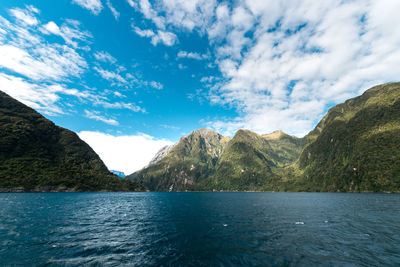 Scenic view of sea and mountains against sky