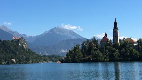 Scenic view of building by mountain against sky