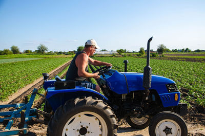 The farmer drives a tractor on the farm. agroindustry and agribusiness. 