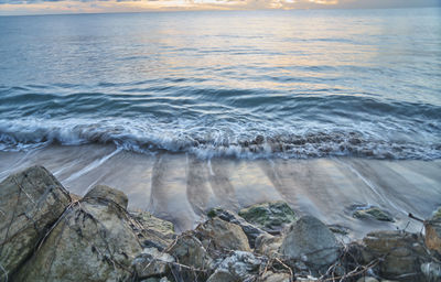 Waves splashing on sea against sky