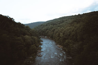 Scenic view of river amidst mountains against sky