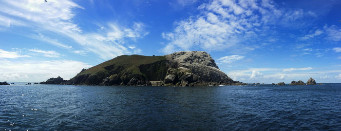 Rock formation in sea against blue sky