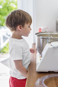 Boy looking at food processor in kitchen