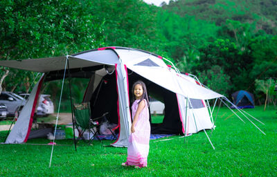 Woman standing in tent on field