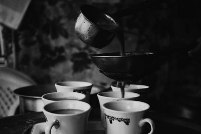 Tea pouring in cup at home