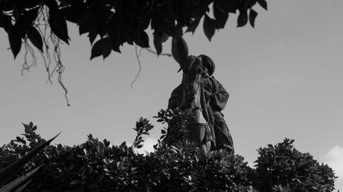 Low angle view of silhouette statue against sky