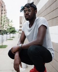 Young man wearing sunglasses sitting outdoors