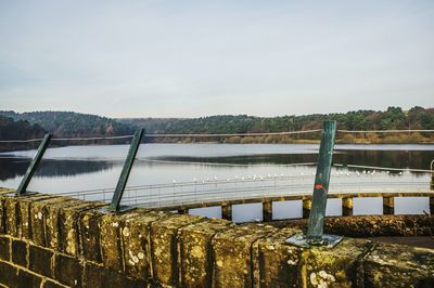 Metal bridge over water against sky