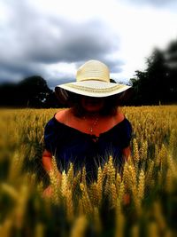 Woman wearing hat on field against sky
