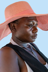 African woman sitting in the sun with summer hat on a beach