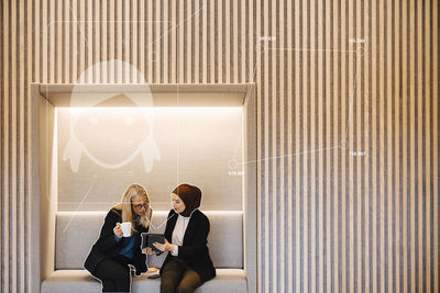 Businesswomen having coffee break and using digital tablet