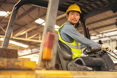 Engineer man forklift driver with a background in an industrial or warehousing factory.