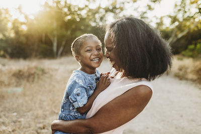 Close up of happy grandmother holding smiling granddaughter outside