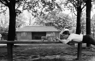 Side view of man standing against trees