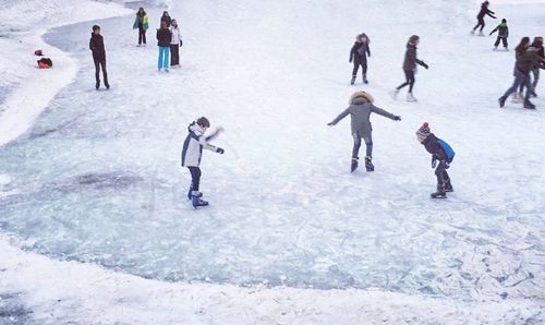 High angle view of people walking on snow