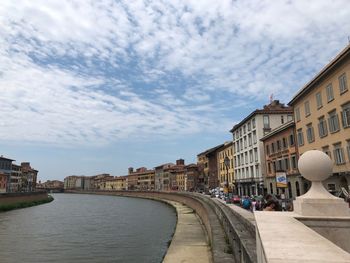 Bridge over canal amidst buildings in city against sky