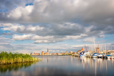 View of boats in lake against cloudy sky